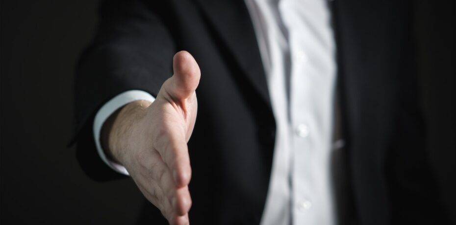 man extending hand out offering handshake following offer of employment