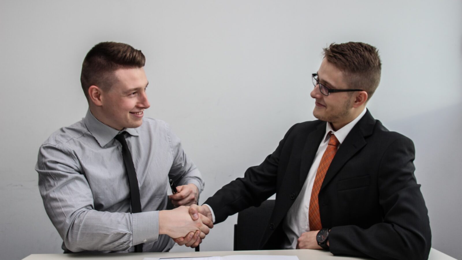 employer and employee shaking hands over employment contract