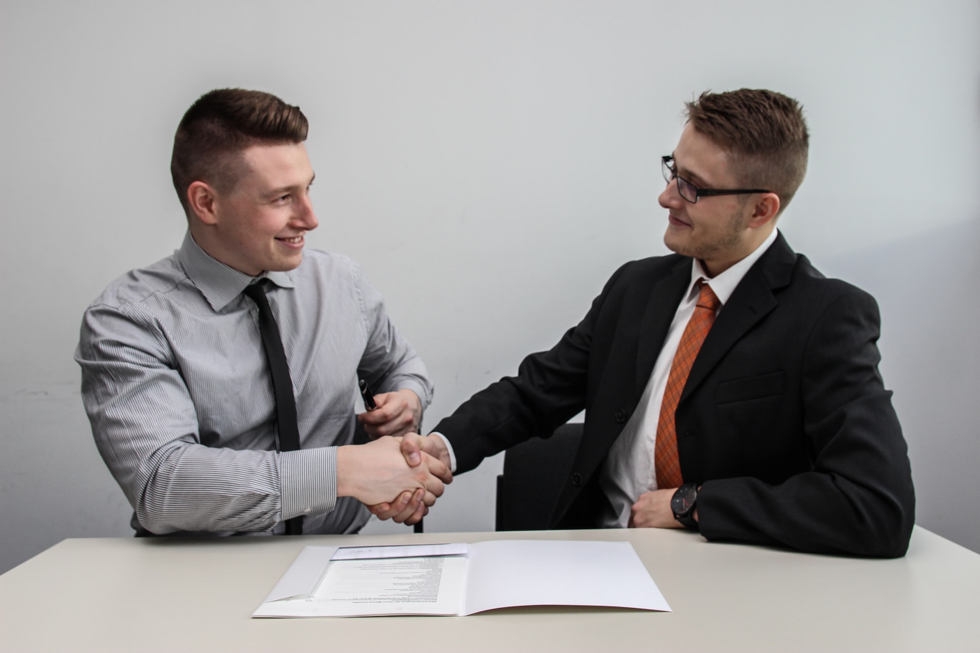 employer and employee shaking hands over employment contract