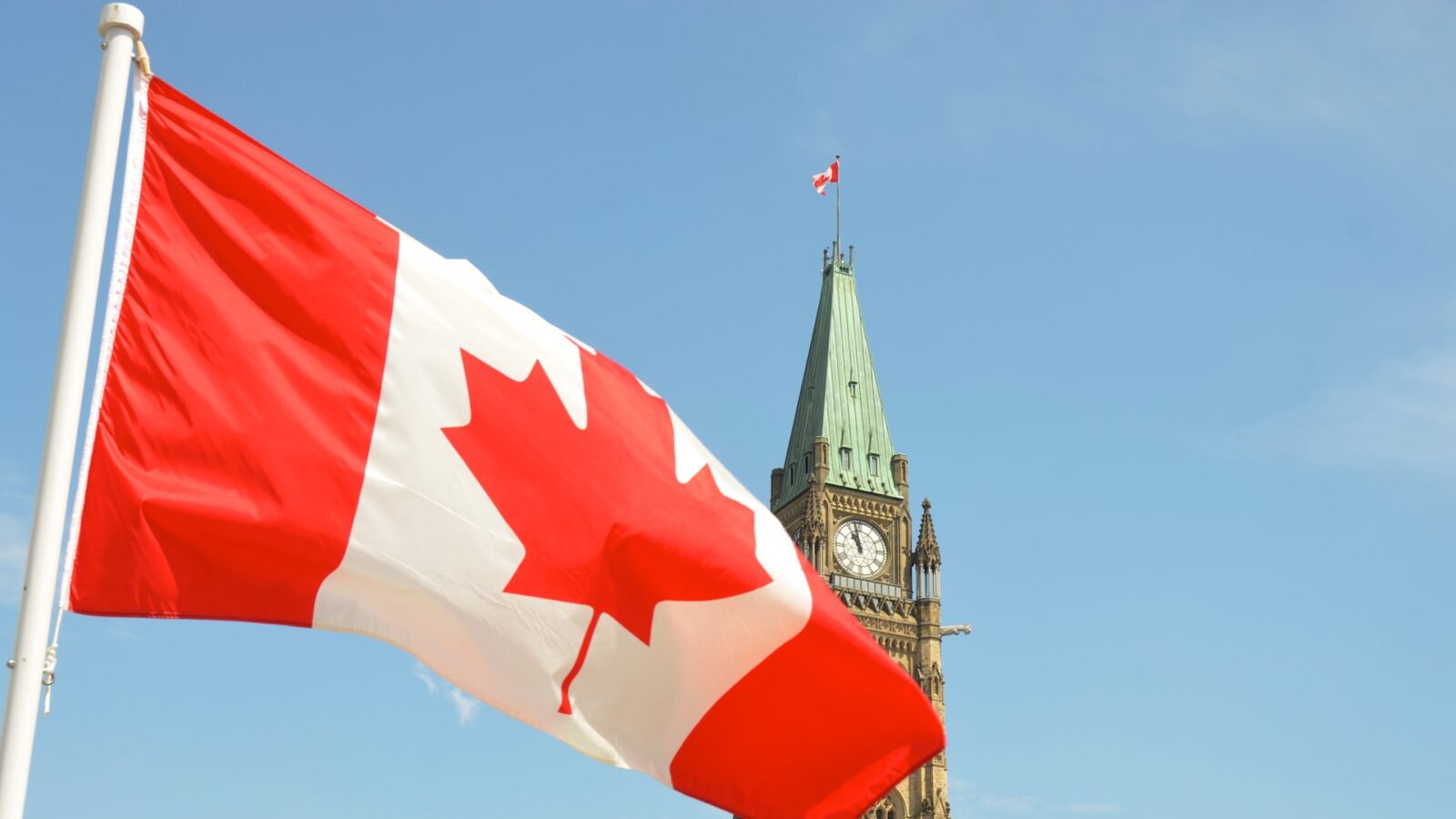 canadian flag flying in front of parliament