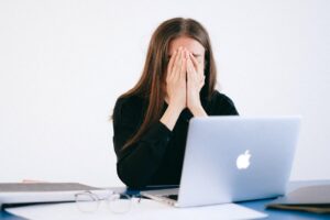 sad woman at desk with computer after being fired from job