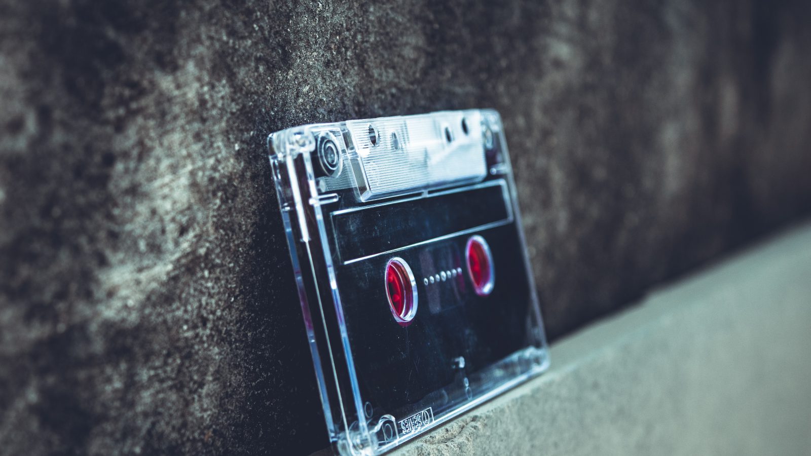 a clear audio cassette tape leaning upside down against a wall
