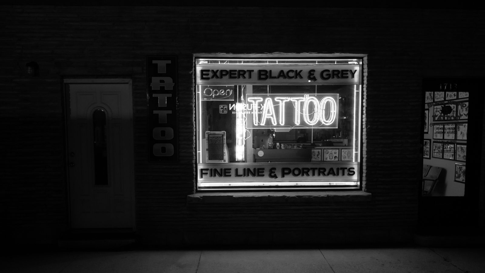 black and white photo of a tattoo parlour sign