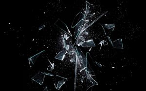 breaking glass against black background representing abusive work environment