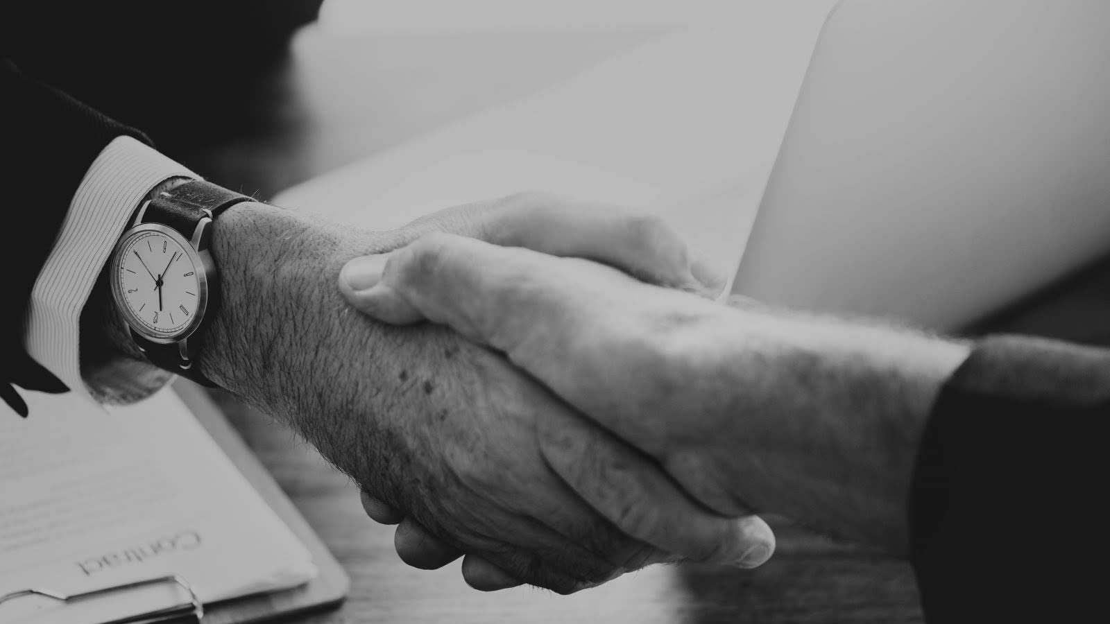black and white image of two hands shaking representing a deal