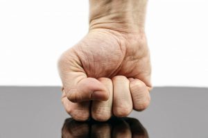 a man's fist coming into contact with a tabletop