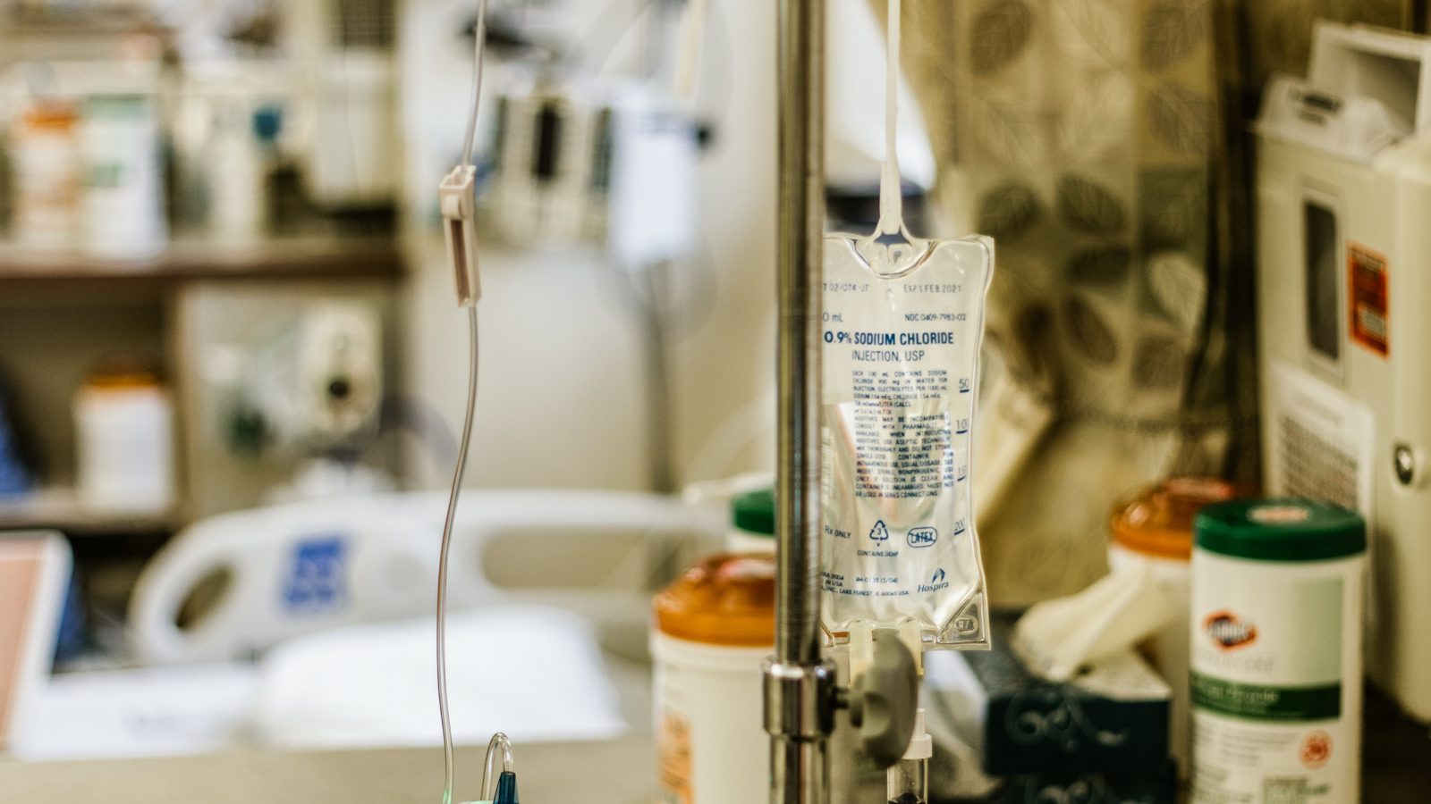 A hospital bedside with an iv drip and medications