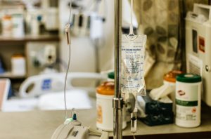 A hospital bedside with an iv drip and medications