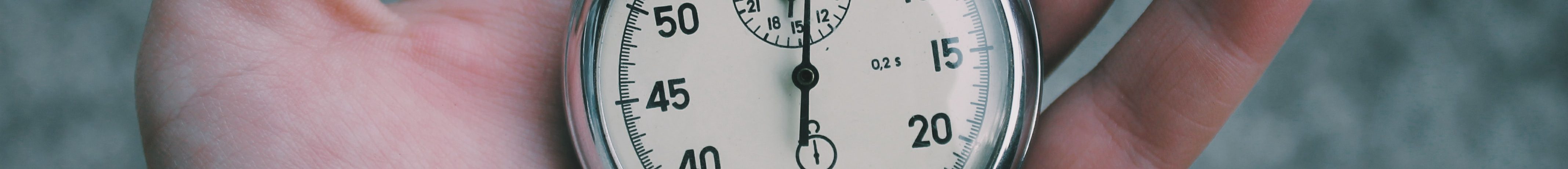 a hand holding a stopwatch, representing faster resolution in small claims court