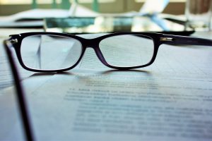 A pair of glasses resting on a document, representing the careful review of an employment contract