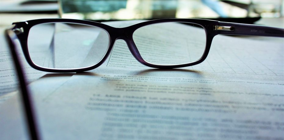 A pair of glasses resting on a document, representing the careful review of an employment contract