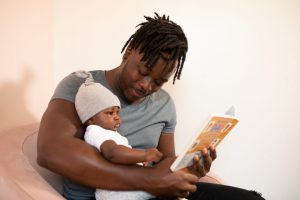 A father holding his baby representing an employee who cannot return to work due to childcare issues