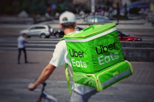 An Uber Eats delivery person on a bike representing the arbitration clause in Uber driver contracts that the SCC struck down