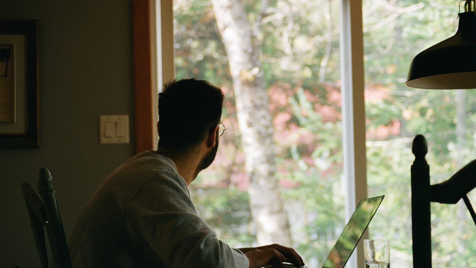 Man working at computer and looking out the window