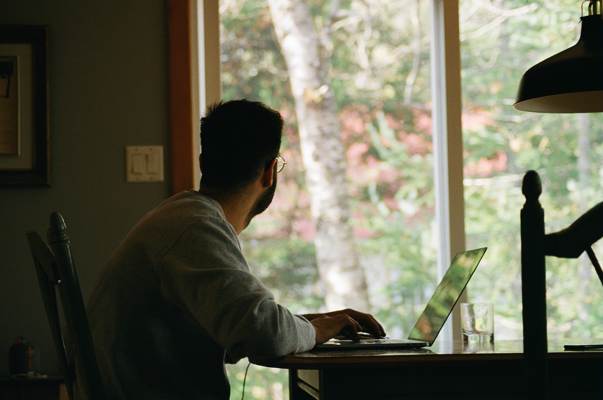 Man working at computer and looking out the window