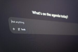 A black chatbot screen with white text encouraging the user to ask anything, representing workplace chatbots.