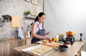 A young woman baking pastries in front of a camera, representing side hustles and moonlighting gigs and conflict of interest employment law policies in Ontario